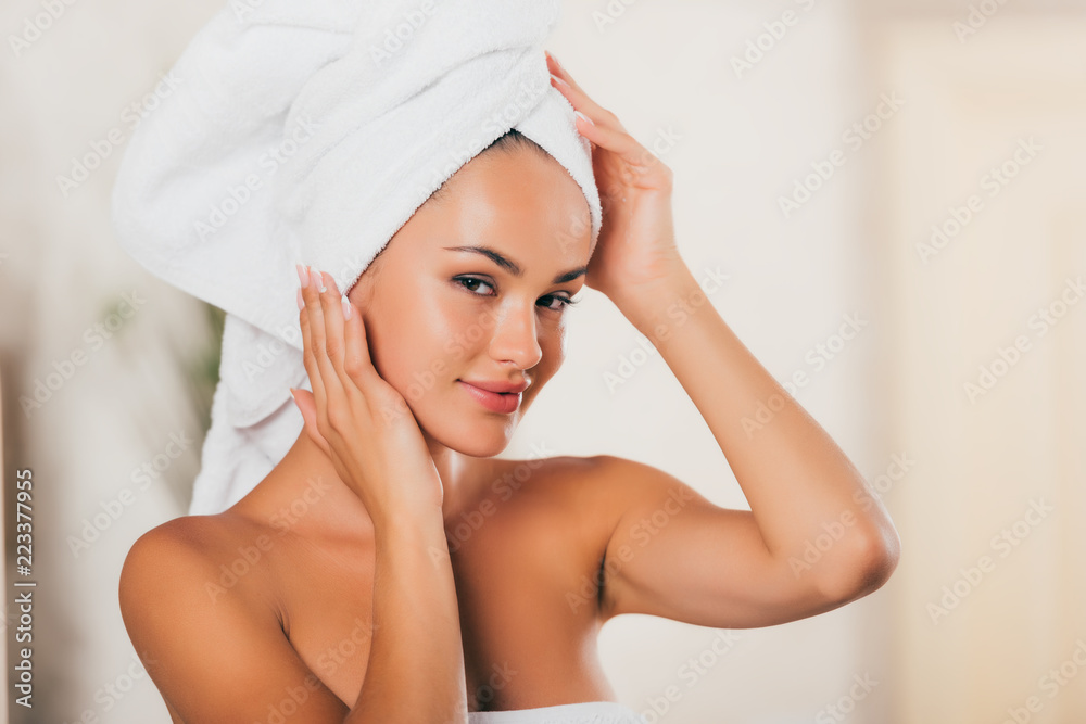 young smiling woman correcting towel on head at spa salon young smiling woman correcting towel on head at spa salon