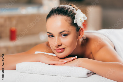 beautiful young woman relaxing at spa salon and looking at camera