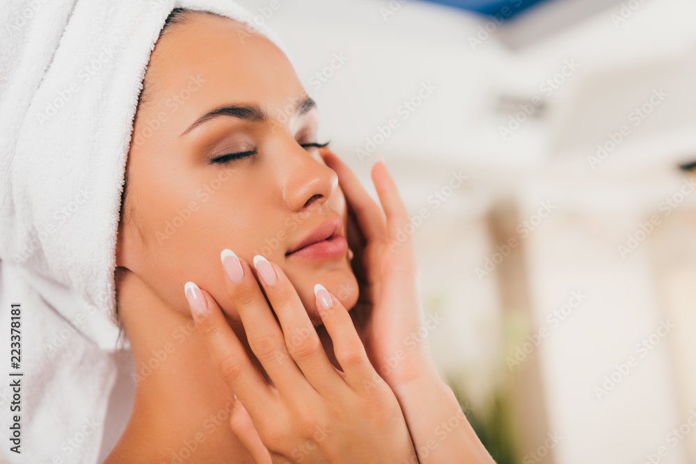 attractive woman in towel on head touching perfect clean face attractive woman in towel on head touching perfect clean face