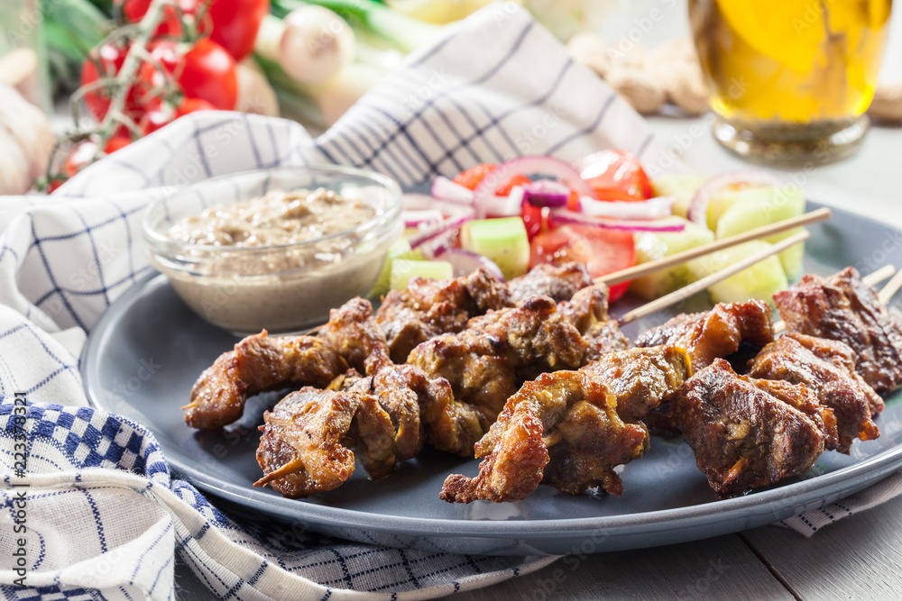 Traditional pork satay with peanut sauce and vegetables Traditional pork satay with peanut sauce and vegetables