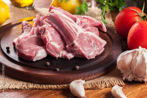 Raw fresh lamb chops on wooden cutting board