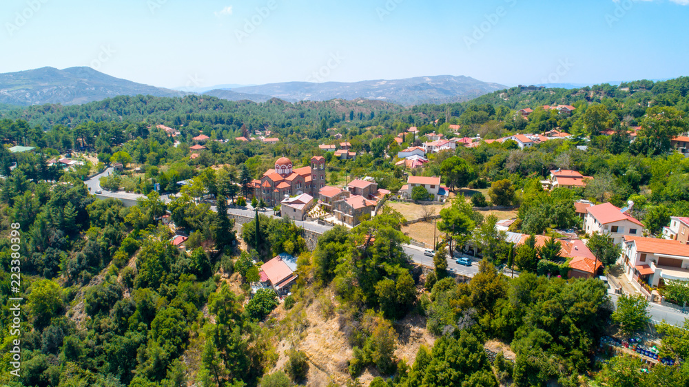 Aerial view of Pano Platres village,winter resort, on Troodos mountains, Limassol, Cyprus. Bird's eye view of pine tree forest, red roof tiled houses, hotels, panagias faneromenis church from above.