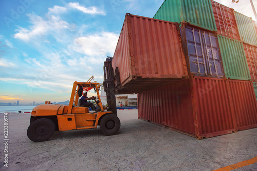 container unit being handling lifting by forklift to transfer from yard to the ship in port terminal