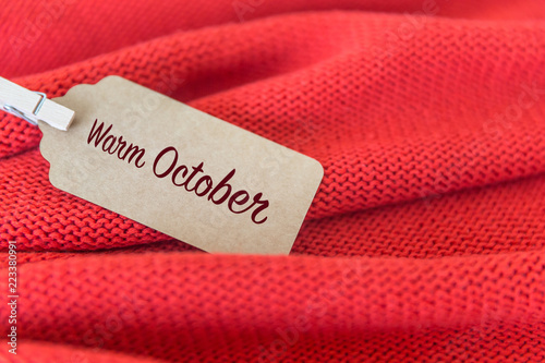Tag with words "Warm October" on a terracotta sweater