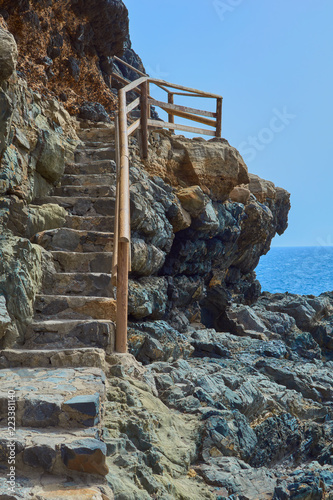 Beautiful views of the blue sea from the staircase with wooden railing and stone the background horizon on a clear day in Ajuy, Fuerteventura, Canary Islands, Spain