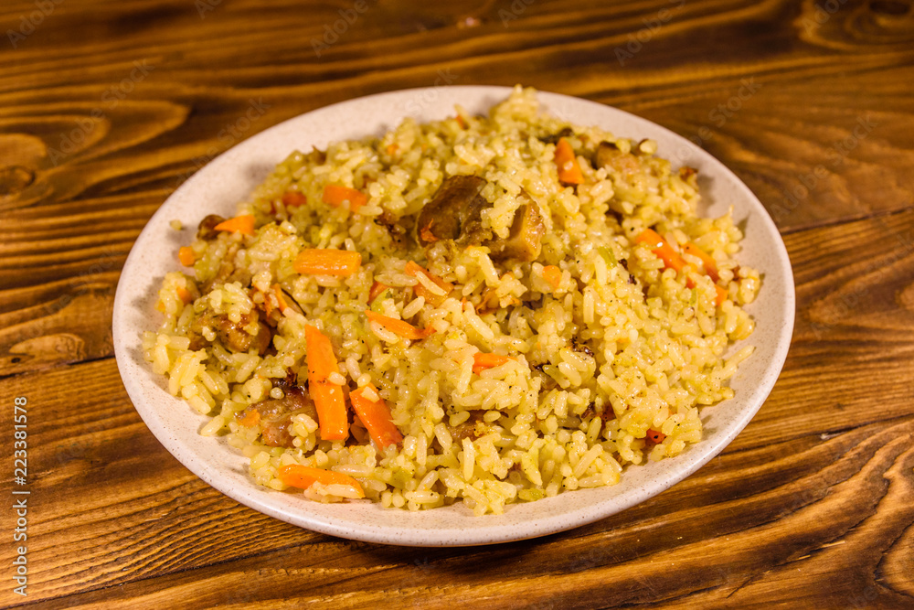 Ceramic plate with pilaf on wooden table Ceramic plate with pilaf on wooden table