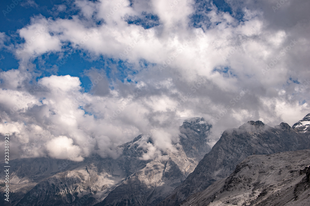 Cime di montagne  nel cielo azzurro con nuvole bianche