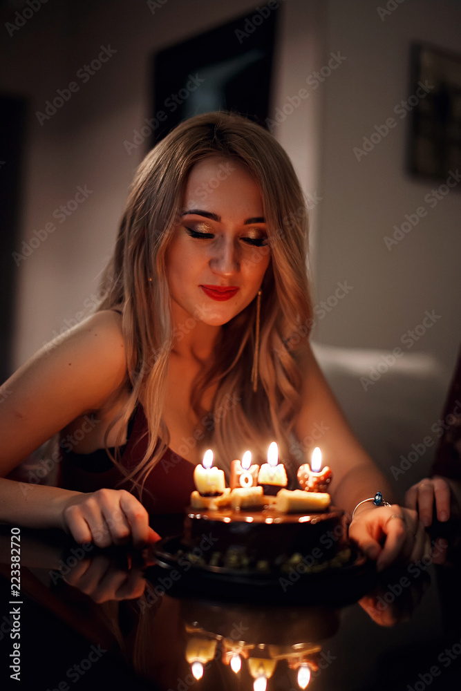 The girl blows into fire of candles on a pie in the dark The girl blows into fire of candles on a pie in the dark
