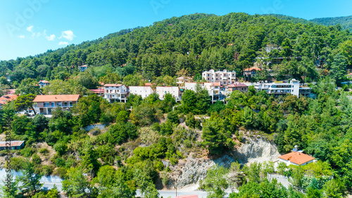 Aerial view of Pano Platres village,winter resort, on Troodos mountains, Limassol, Cyprus. Bird's eye view of pine tree forest, red roof tiled houses, hotels, panagias faneromenis church from above. photo