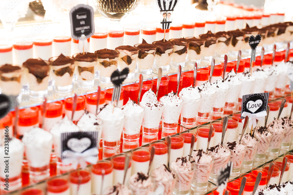 Fototapeta premium Delicious sweets on wedding candy buffet with desserts, cupcakes