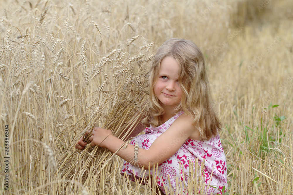Little blonde girl walking on a wheat field Little blonde girl walking on a wheat field