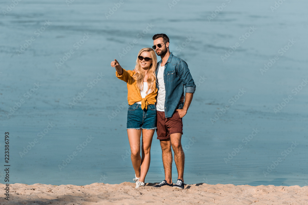 girlfriend pointing on something to boyfriend on beach girlfriend pointing on something to boyfriend on beach