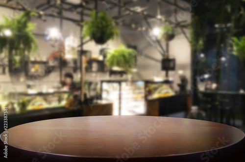 Selected focus empty brown wooden table and Coffee shop or restaurent blur background with bokeh image. for your photomontage or product display