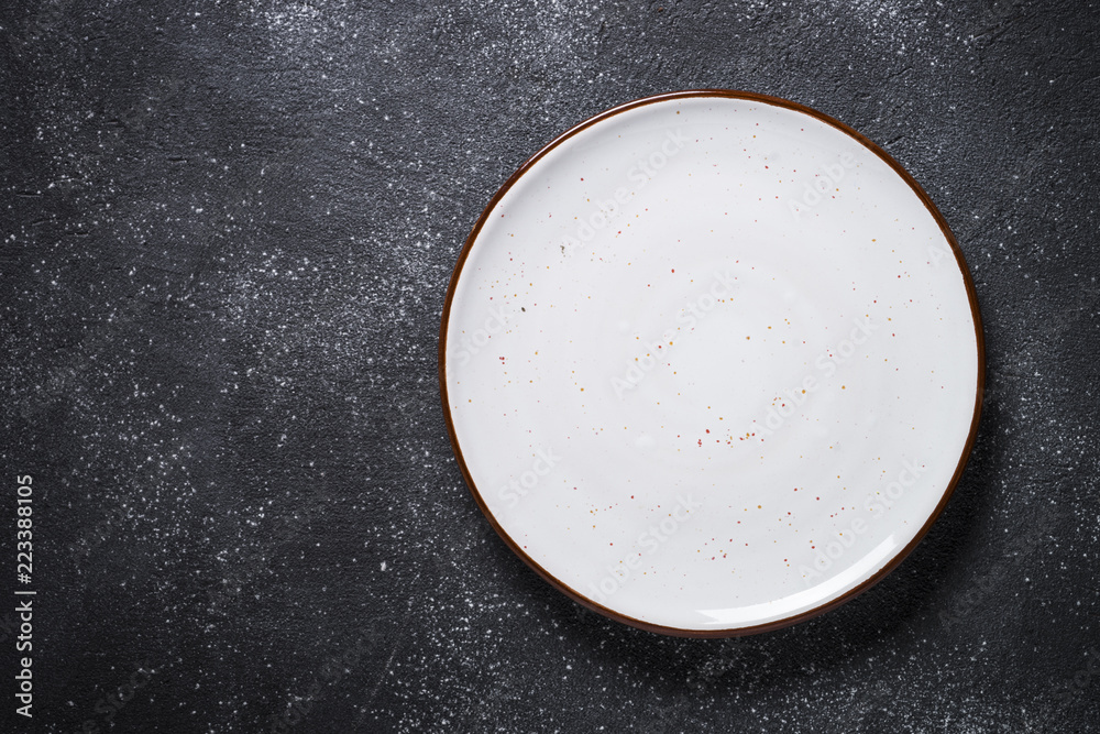 Empty white plate on dark stone table top view. Empty white plate on dark stone table top view.
