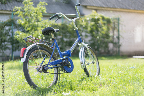 children's bicycle on the grass. Blue teen bike on a green lawn in the yard