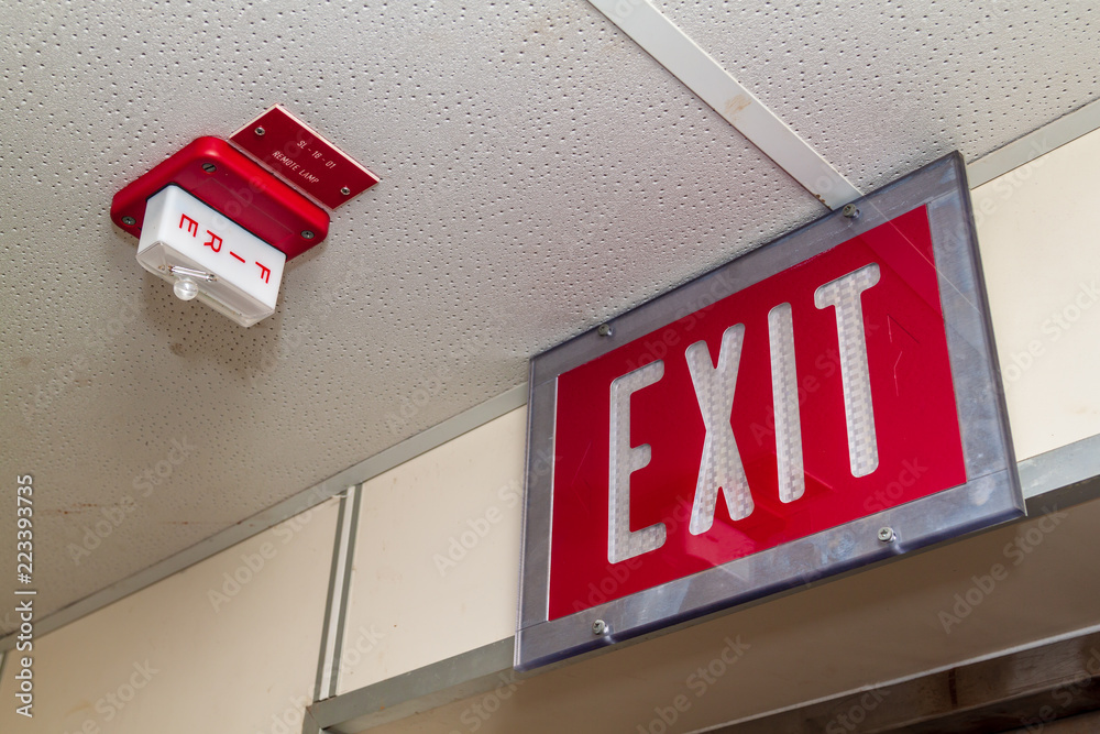 Red Fire alarm switch on the wall next to the door,Fire alarm switch.Break  glass and pull down button to activate for warning and security system with  hand and direction arrow, Stock Photo