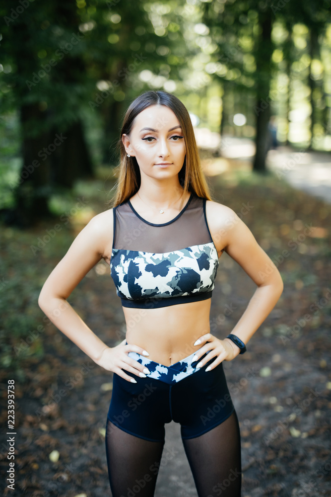 Portrait of attractive fit woman standing in the park after training, copy space Portrait of attractive fit woman standing in the park after training, copy space