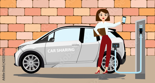 Woman charges an electric car at a charging station for electric vehicles. Woman next to the electric car.