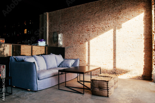 Bangkok old loft brick wall bar with couch and zack stool, natural evening light