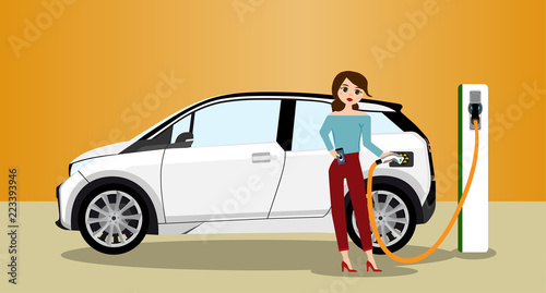 Woman charges an electric car at a charging station for electric vehicles. Woman next to the electric car.