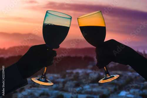 Photography Hands of female's and male's with glass of wine on San Francisco city background