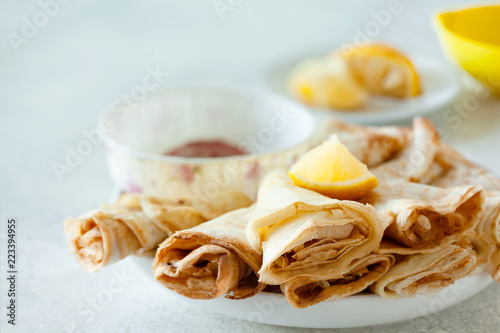 Lemon crepes on the plate with strawberry sauce