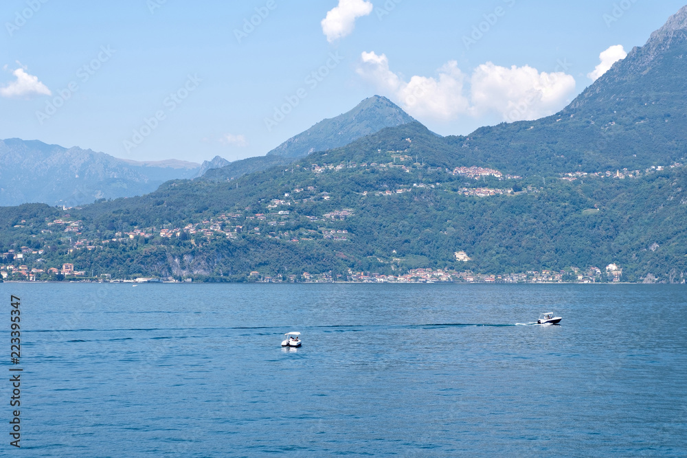 Boats cruising on azure water of Lake Como