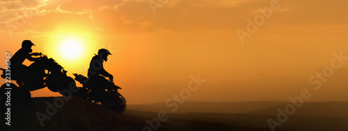 Silhouette ATV or Quad bikes Jump in sunset. photo