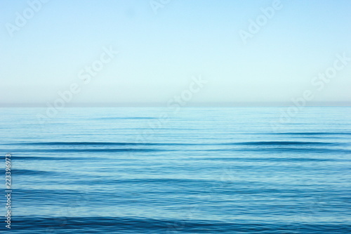 Calm sea ripple with horizon over water