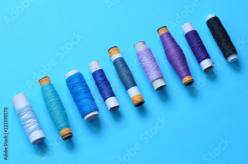 blue thread reels for sewing on a blue background. photo thread on. threads of shades of blue. sewing, needlework, handmade. Use for backgrounds, wallpapers, posters, advertisements, card