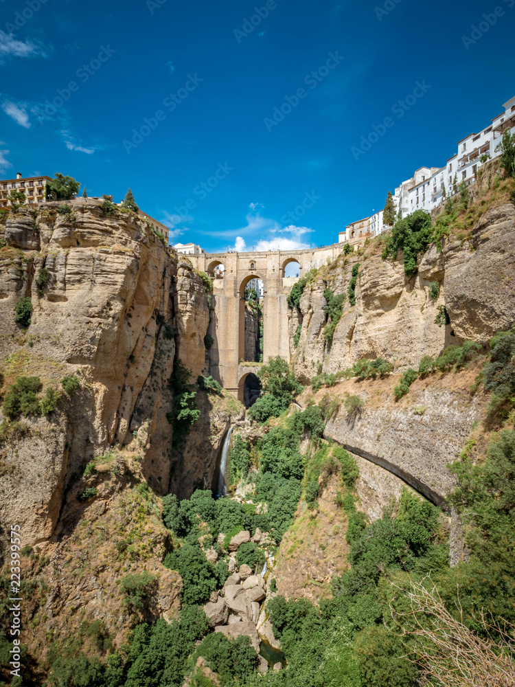 Panorama view of the Puente Nuevo bridge and the houses built on the edge of the cliff, in the ancient city of Ronda, Spain