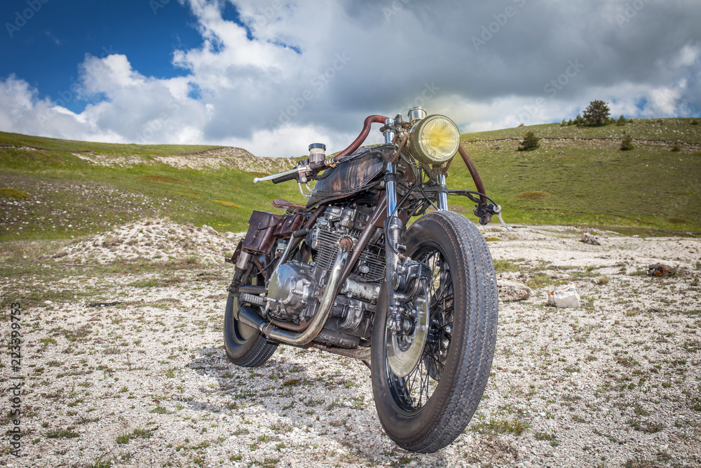 Rat custom motorcycle in a desolated mountain land. Post apocalyptic concept Rat custom motorcycle in a desolated mountain land. Post apocalyptic concept