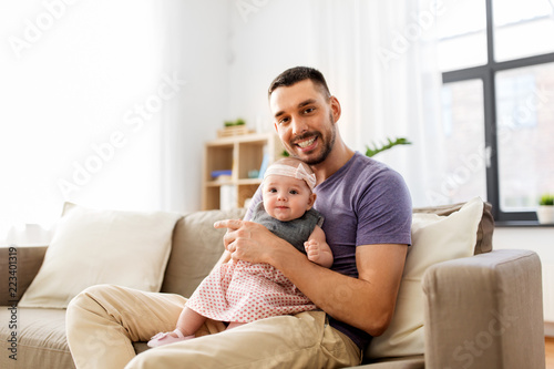 family, fatherhood and people concept - father with little baby girl at home