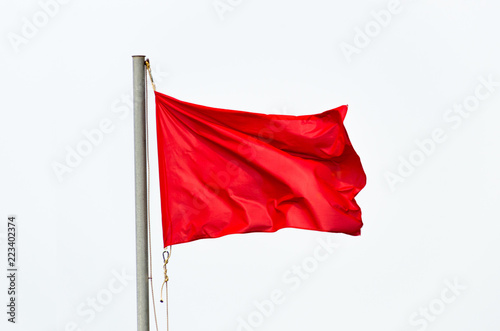 Red flag waving isolated over white