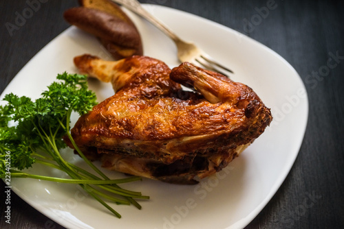 baked chicken on a plate, on a black background