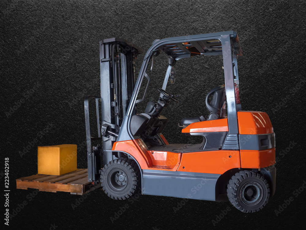 Forklift handling the box of spare parts on pallet in warehouse, isolated on black.