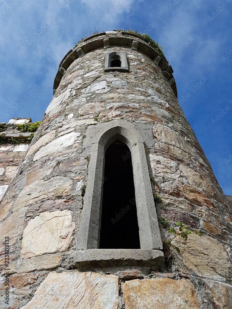 Upwards view of an Old Stone Castle Tower with Arched Windows