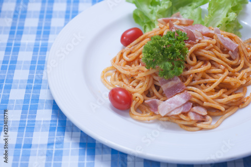 close up of delicious spaghetti with bacon and tomatoes on white plate and , Select focus