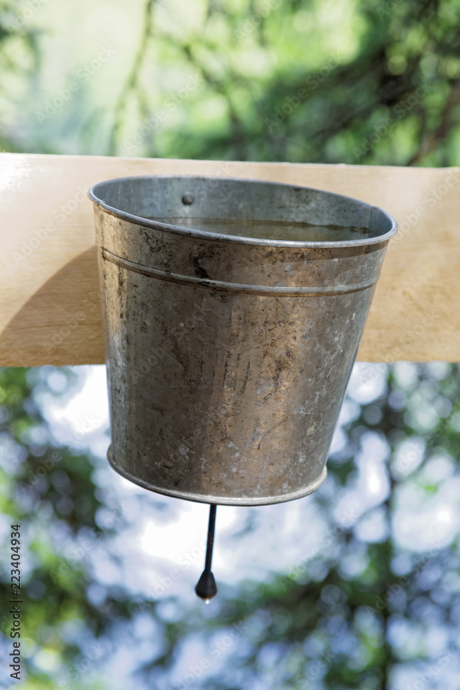 Old-fashioned tin hand wash with water nailed to the board