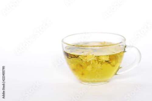 Photo of herbal tea in a transparent cup. flowers and leaves of herbs. flowers of linden and elderberry, leaves of mint. time for relaxation. hot tea. use for background, text, for your design, card