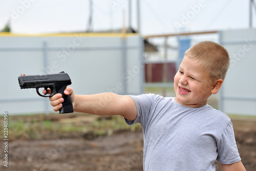 A boy shoots a pistol