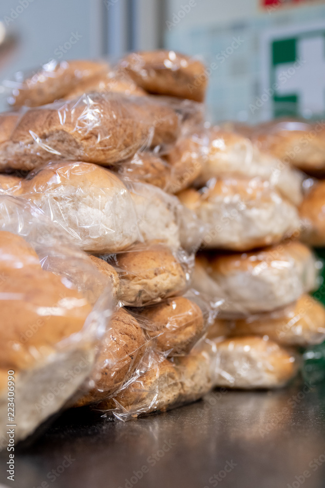 Packs of bread rolls lined up on a kitchen table. Packs of bread rolls lined up on a kitchen table.