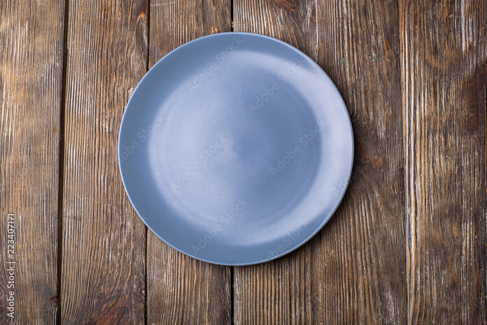 Blue Round Plate on brown wooden table background Blue Round Plate on brown wooden table background