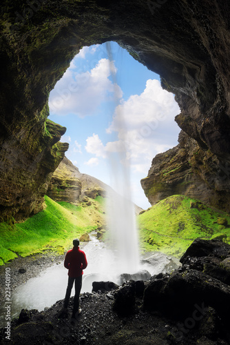 Tourist looks at the big waterfall in Iceland