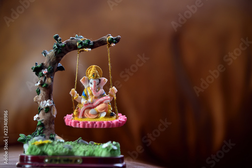 Hindu God-Ganesha in art form sitting on a swing. Hindu Lord Ganesha provide success, prosperity and remover trouble.