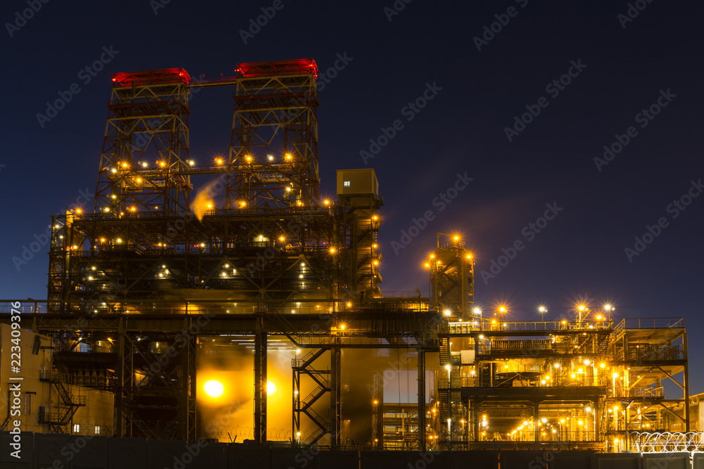 Night industrial landscape with bright lights of lanterns - 4-drum delayed coking unit in a petroleum refinery - obrazy, fototapety, plakaty 