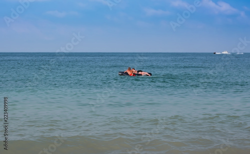 The boys lie on an inflatable mattress in the sea