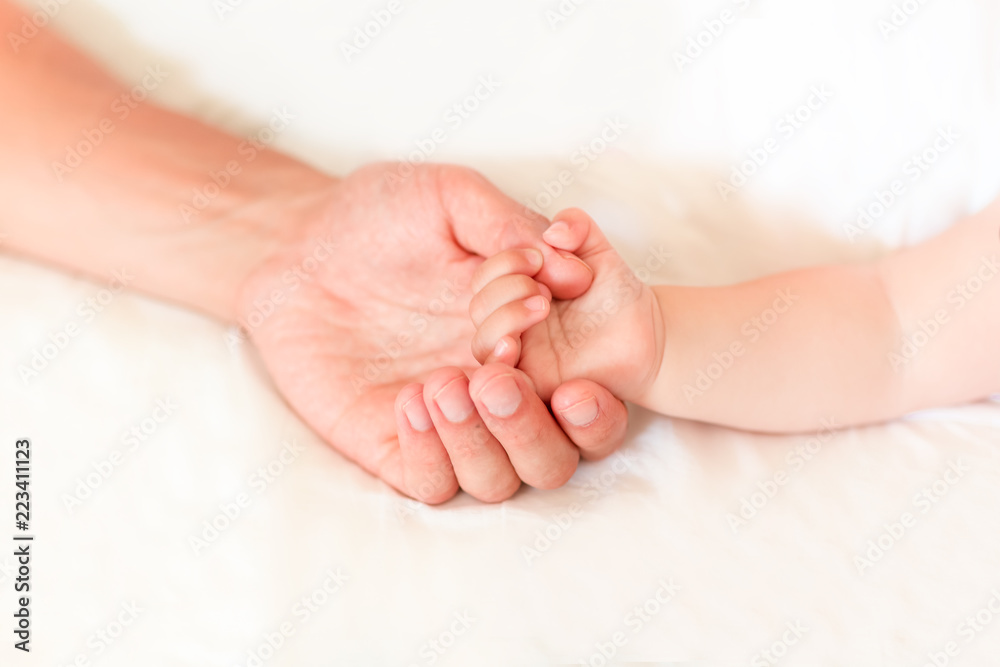 Father holding the hand of his new born son Father holding the hand of his new born son