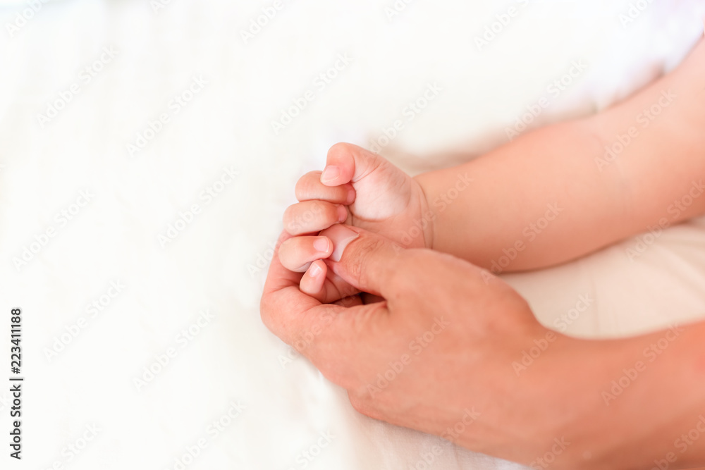 Father holding the hand of his new born son Father holding the hand of his new born son