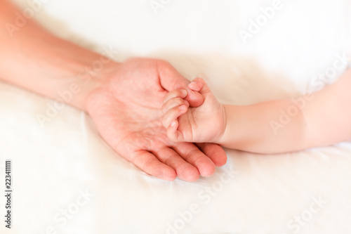Father holding the hand of his new born son